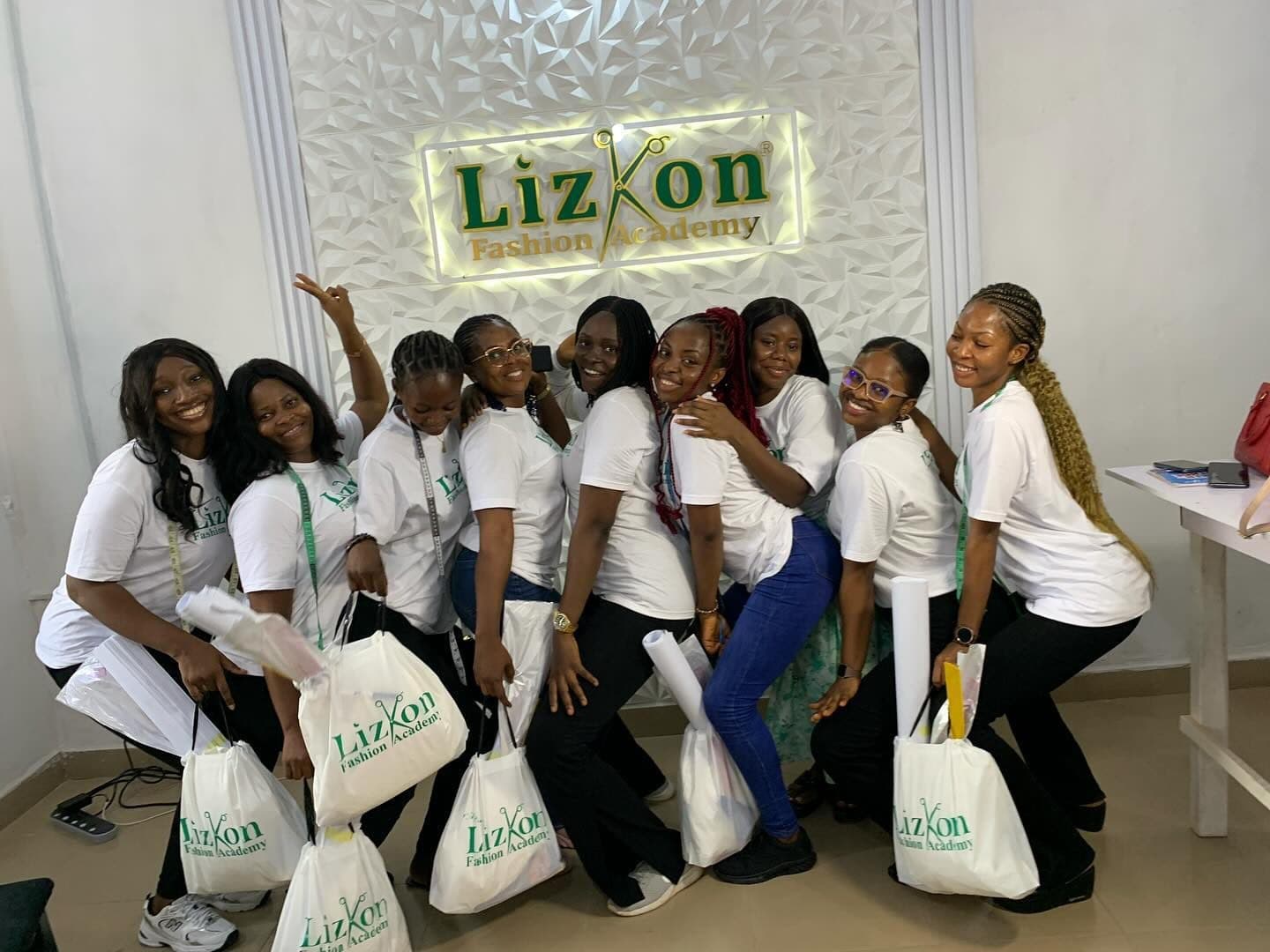 Graduating students in front of the academy sign