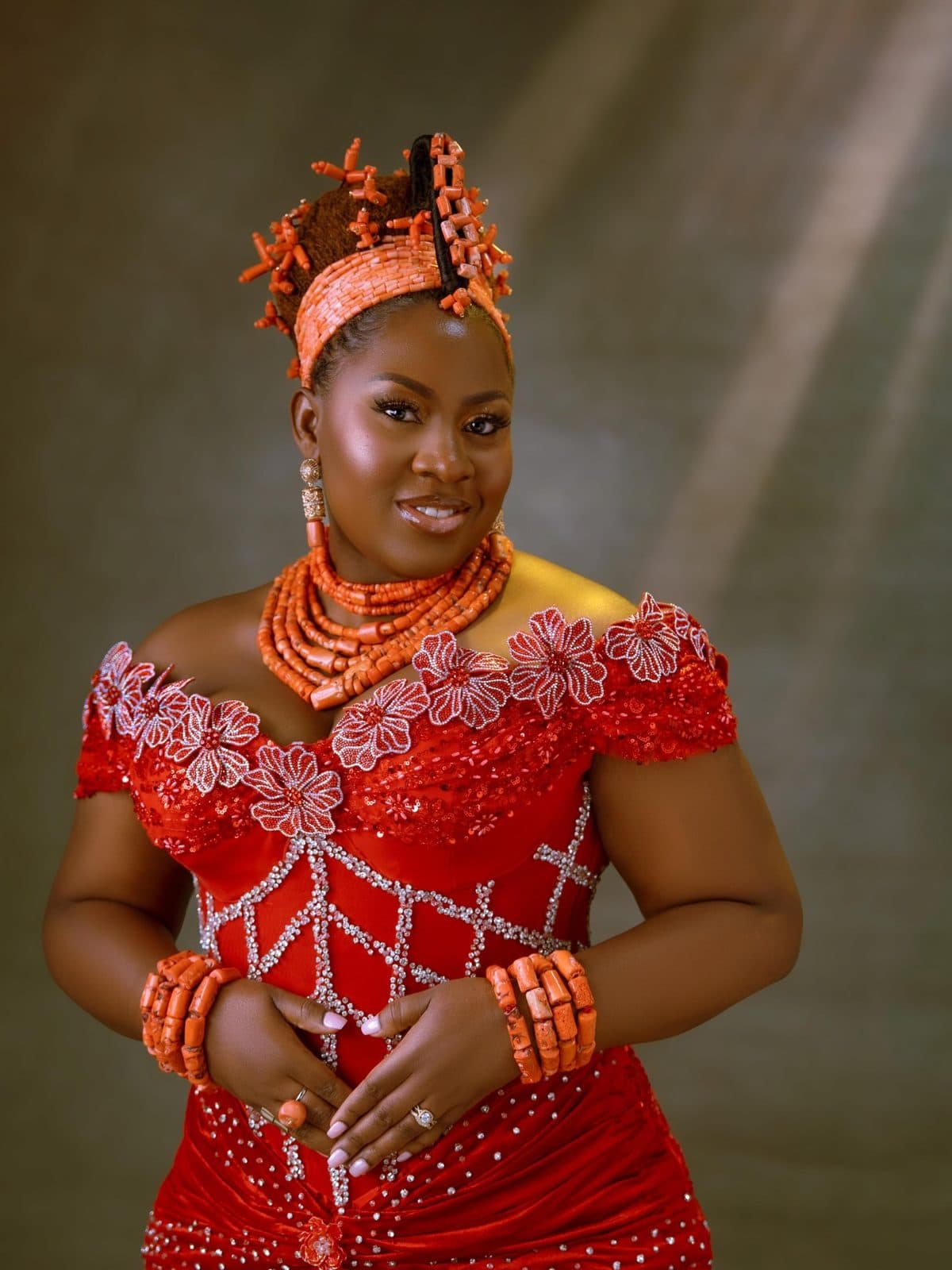 A traditional bride in red lace and coral beads