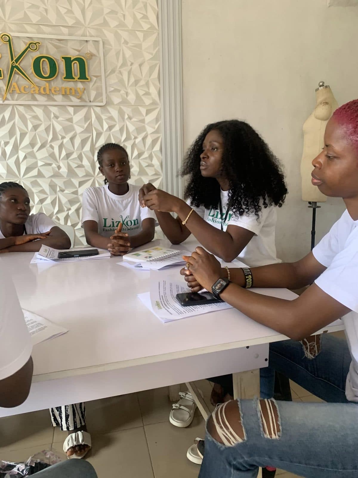 A tutor teaching students at a drafting table