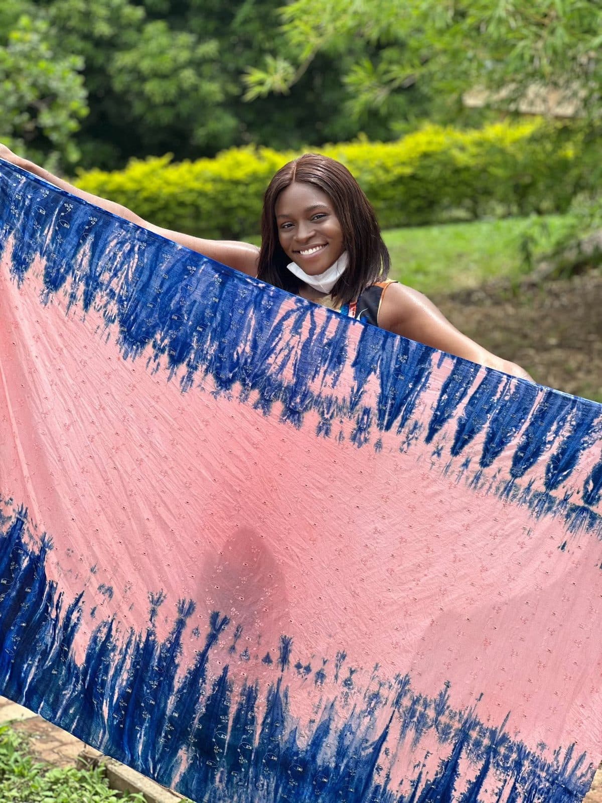 A length of hand-dyed adire held up outdoors