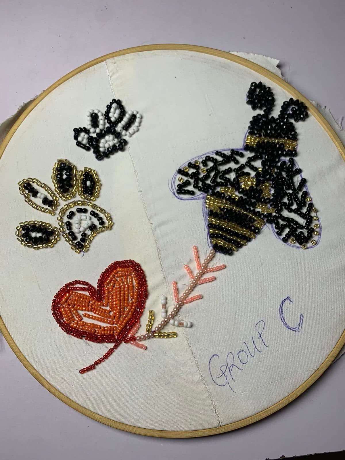 A beaded bee on an embroidery hoop