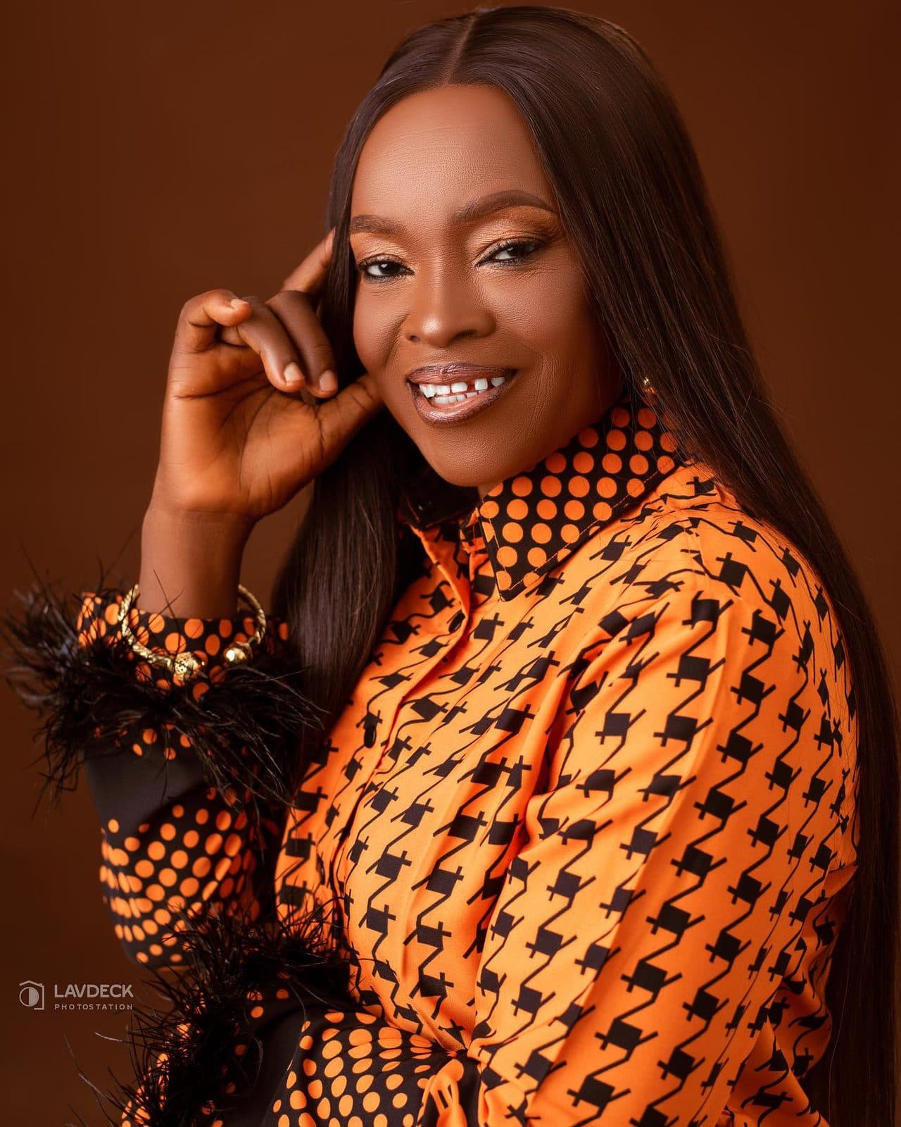 Portrait of the client in her orange Ankara outfit