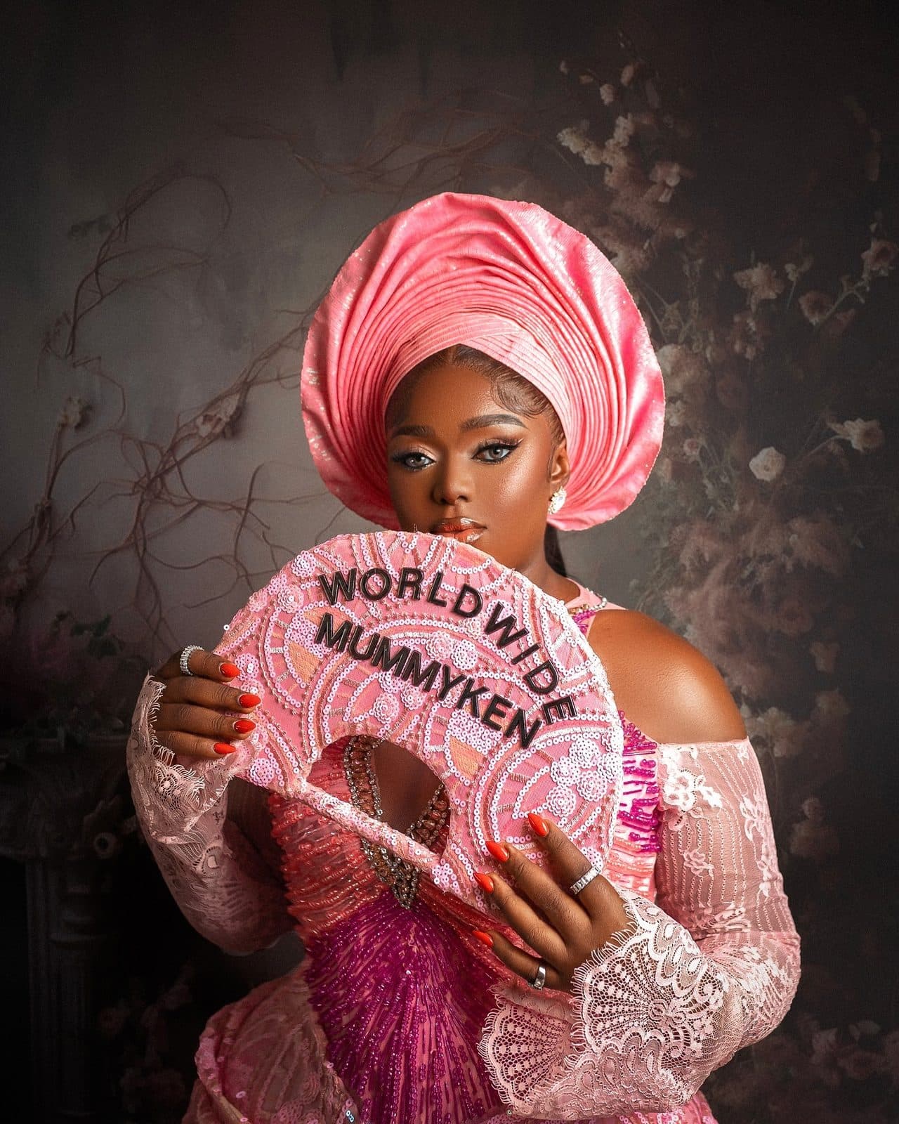 The guest holding a pink hand fan