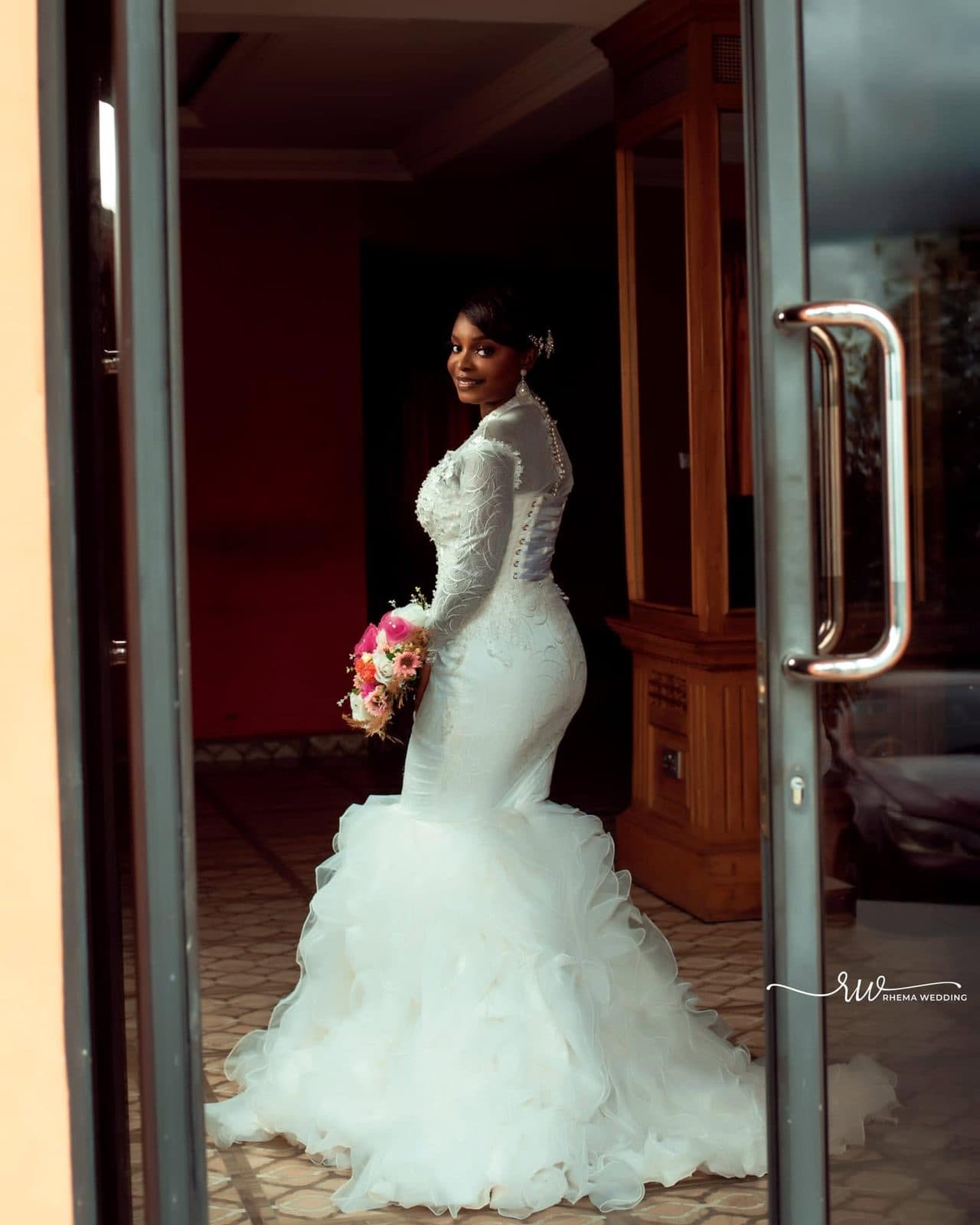 The bride in a doorway in her mermaid gown