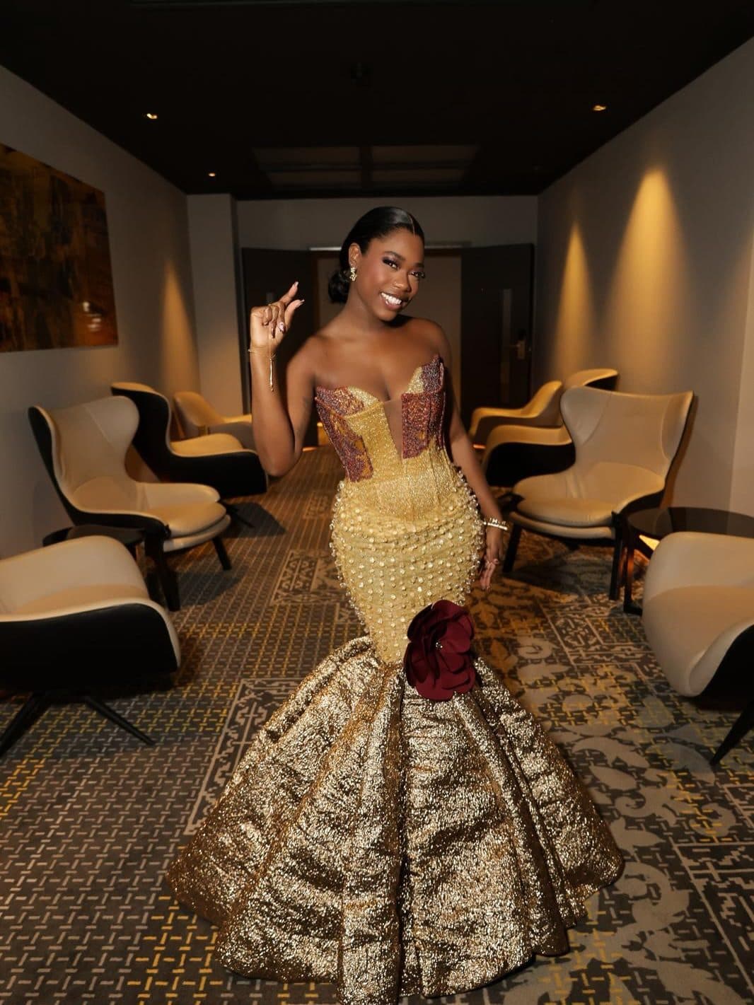 The client seated in a lounge in the gold gown