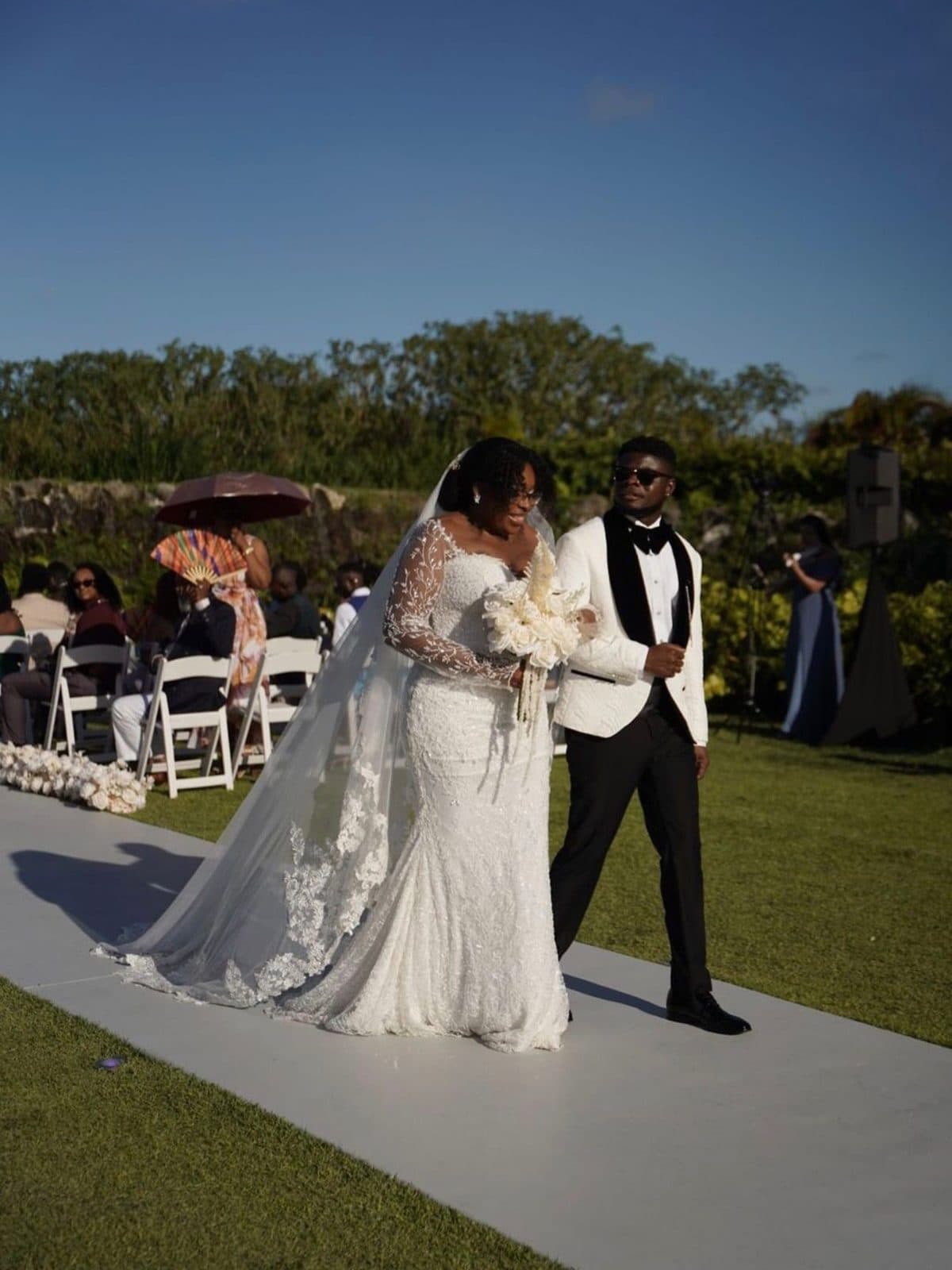 The bride and groom walking down the aisle outdoors