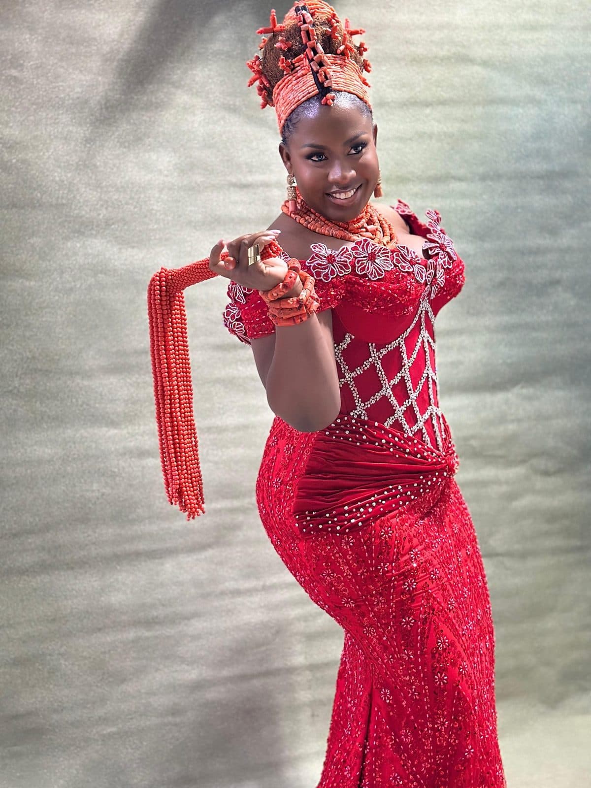 A traditional bride in red beaded lace and coral beads