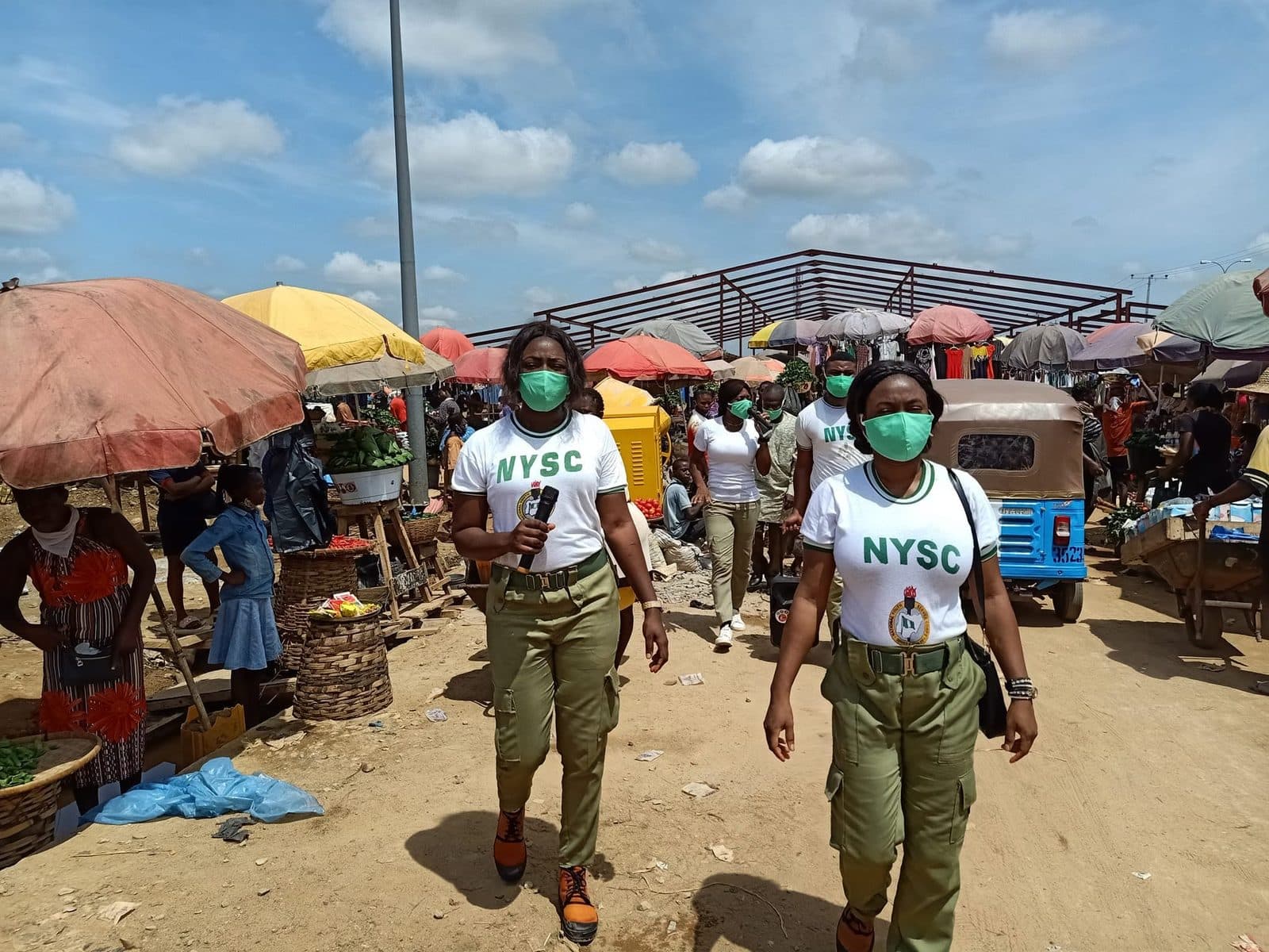 Corps members distributing face masks at a market in 2020