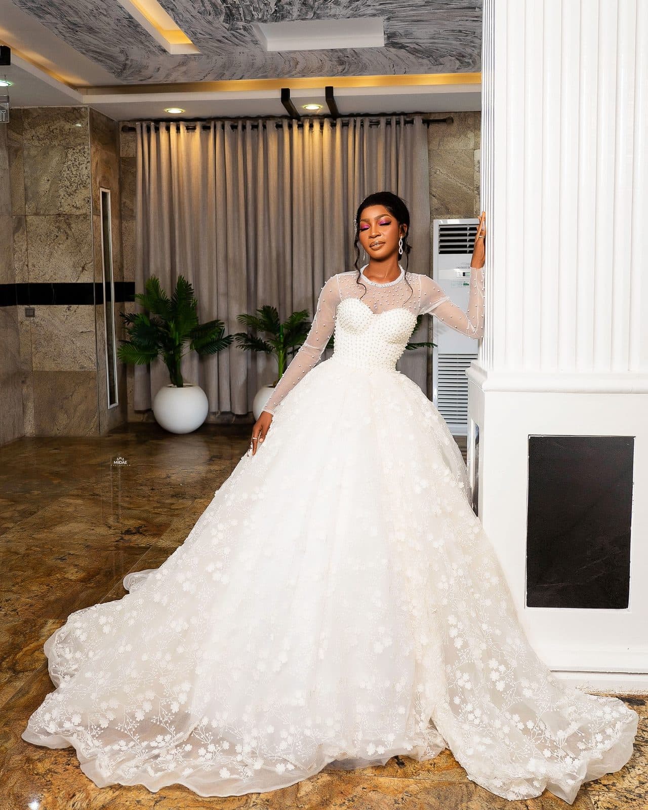 A student's final project, a white ball gown, photographed in a hotel lobby