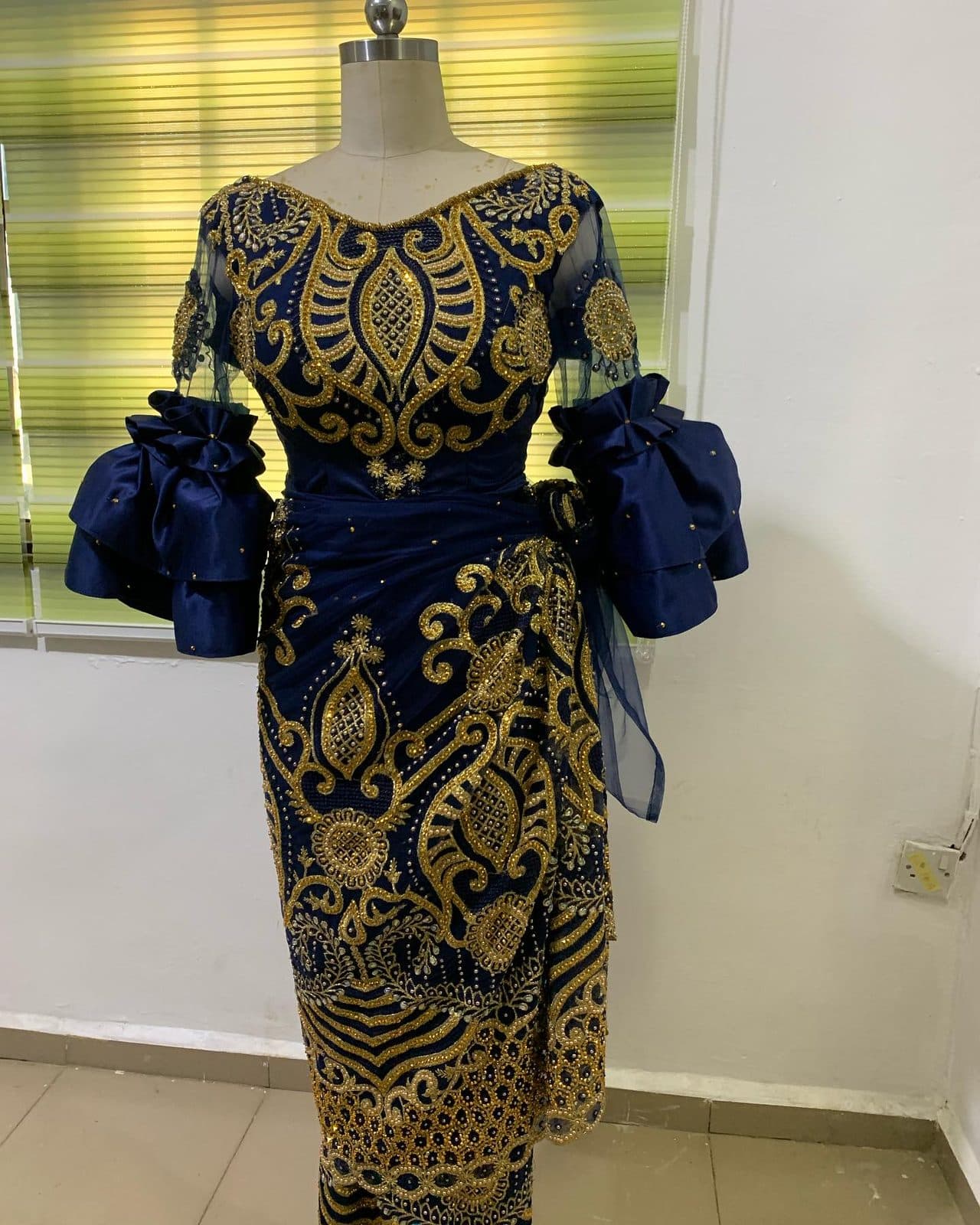 A brocade dress on a dress form in the studio