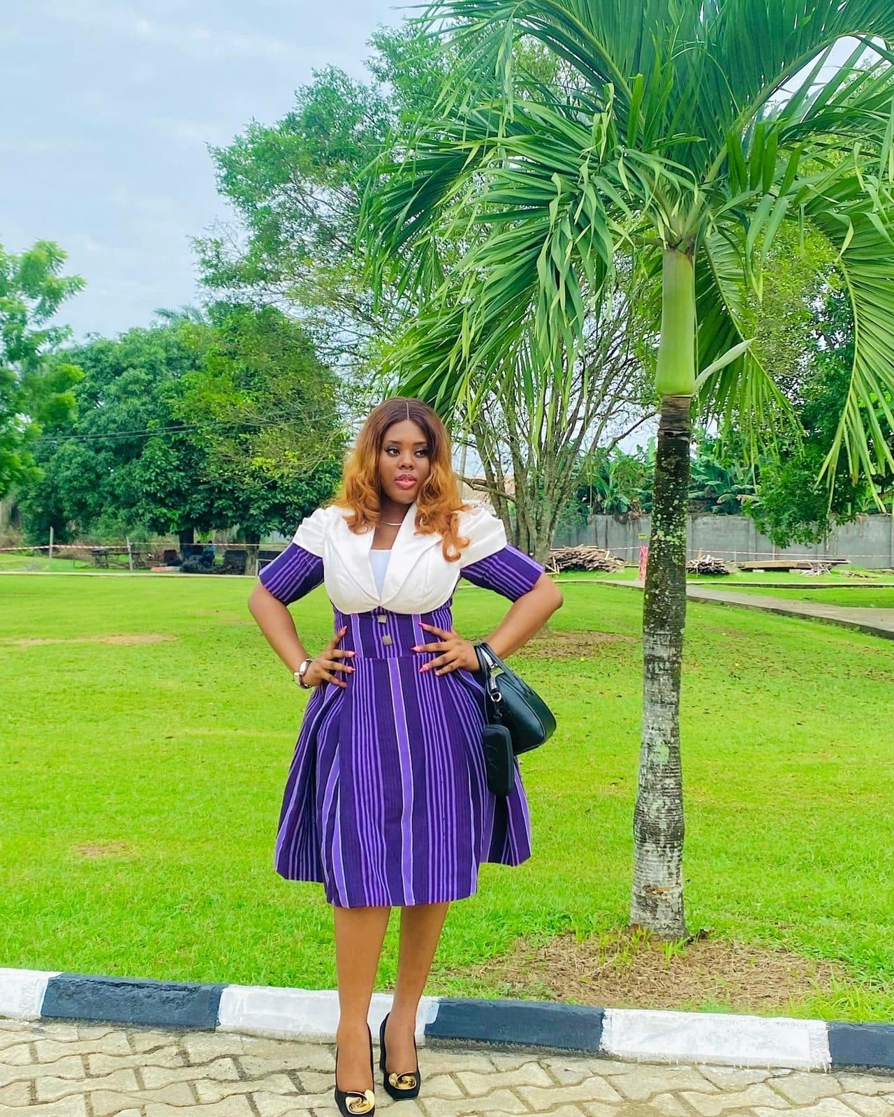 A woman in a purple corporate dress with aso-oke detail