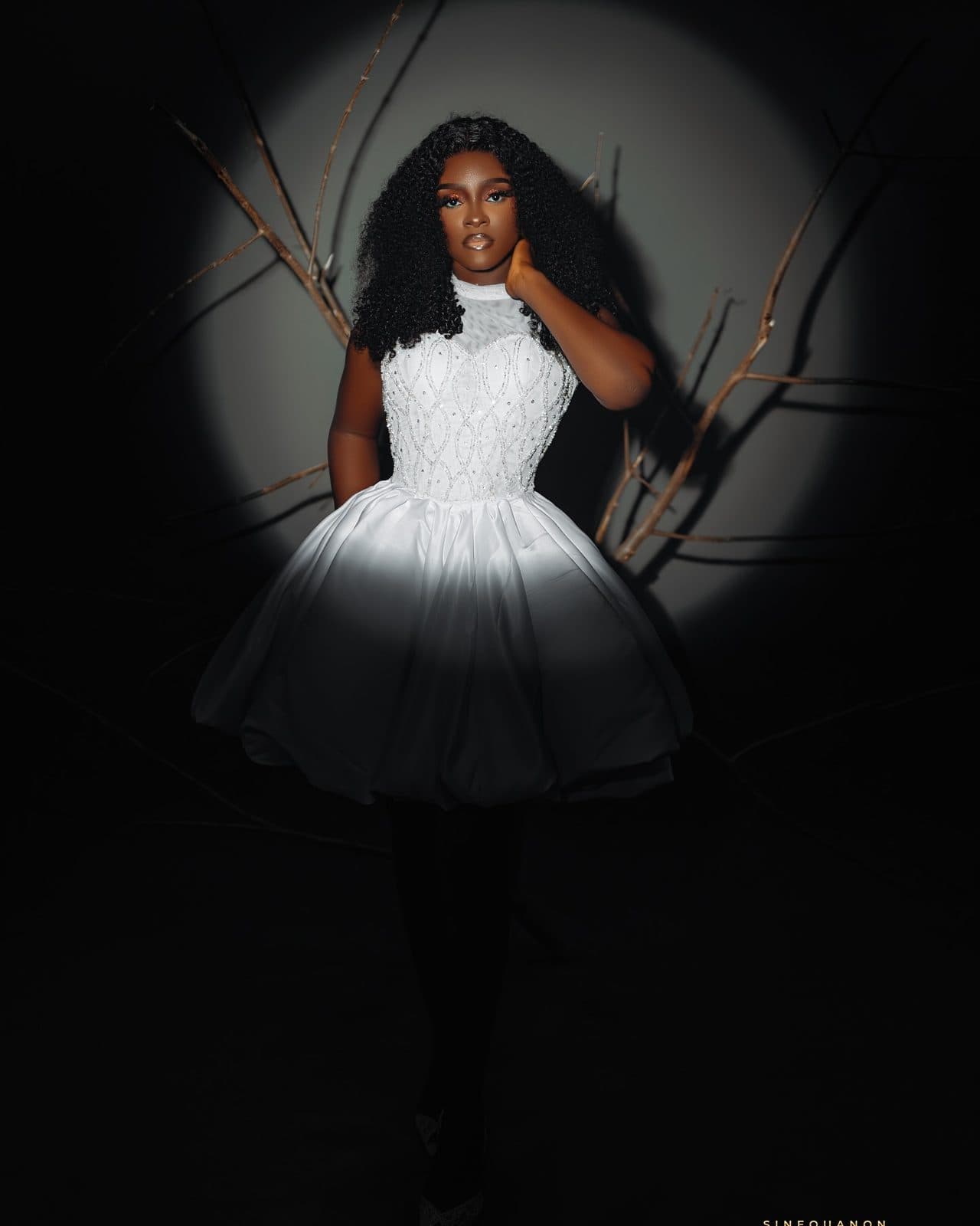 A woman in a white beaded mini dress with a full skirt