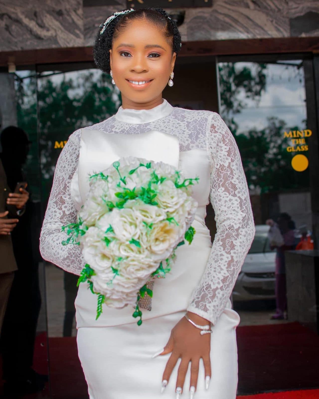 A bride in a fitted white civil wedding dress holding a bouquet