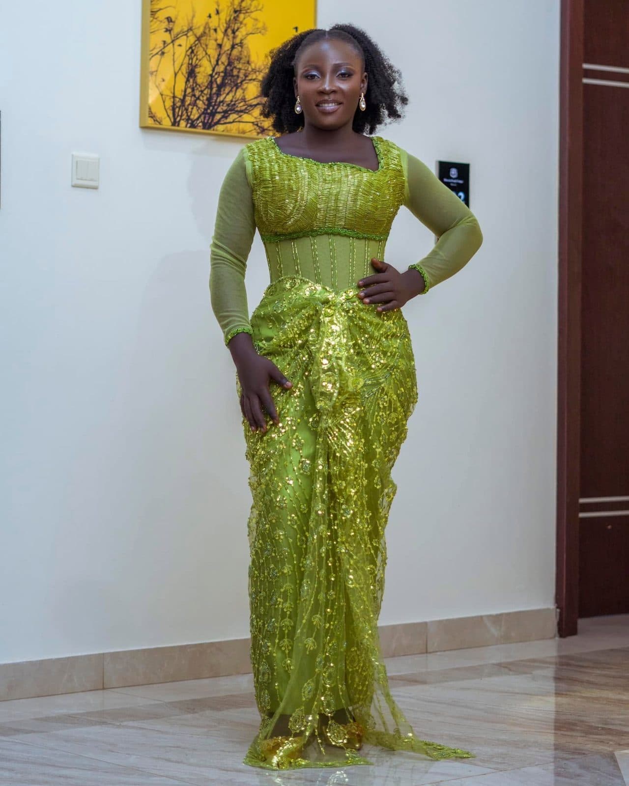 A woman in a fitted olive lace outfit