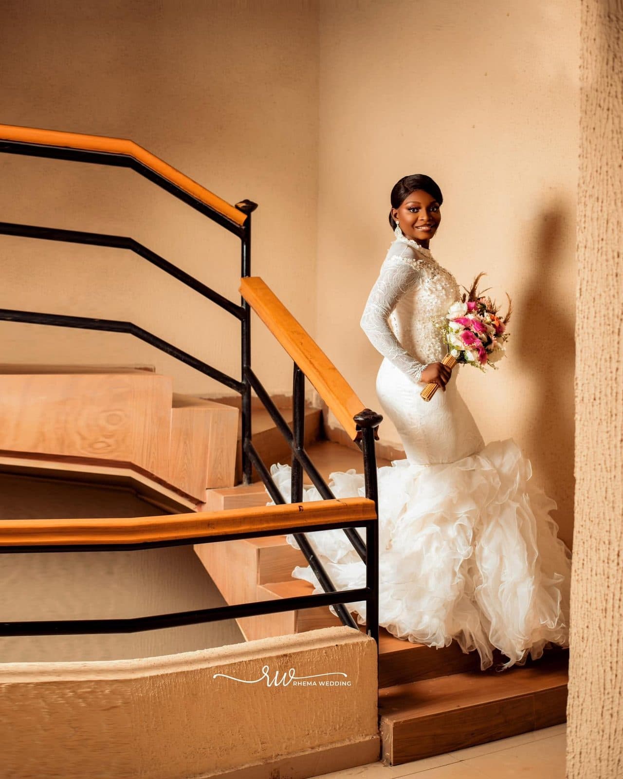 The bride on a staircase holding her bouquet